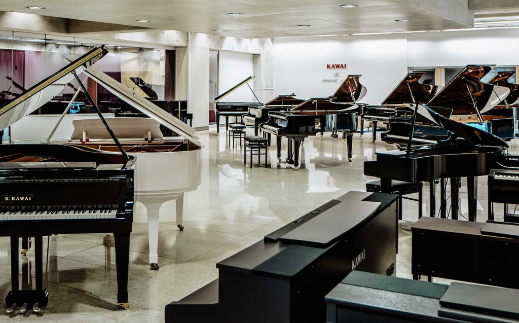 Showroom with various grand pianos on display.