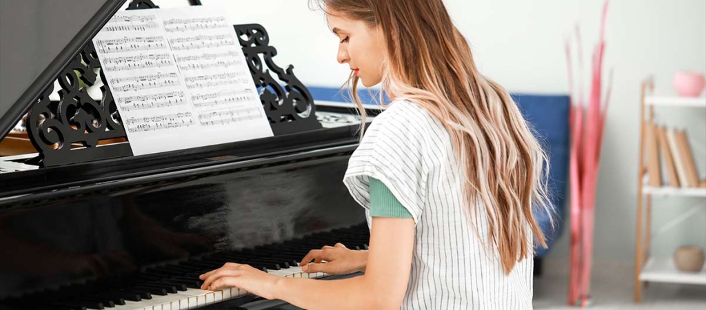 Woman playing piano with sheet music.