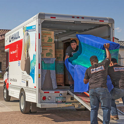 Men loading furniture into a moving truck.