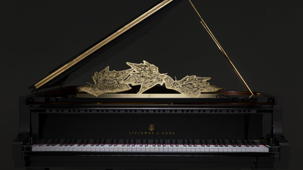 Intricate golden dragon design on a Steinway & Sons grand piano lid.