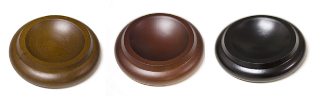 Three round wooden bowls in different colors.