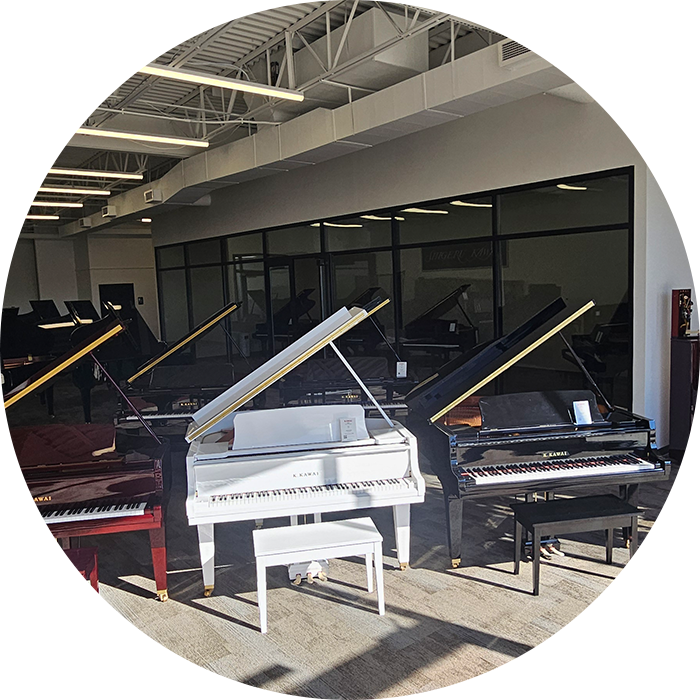 Showroom with multiple grand pianos displayed.