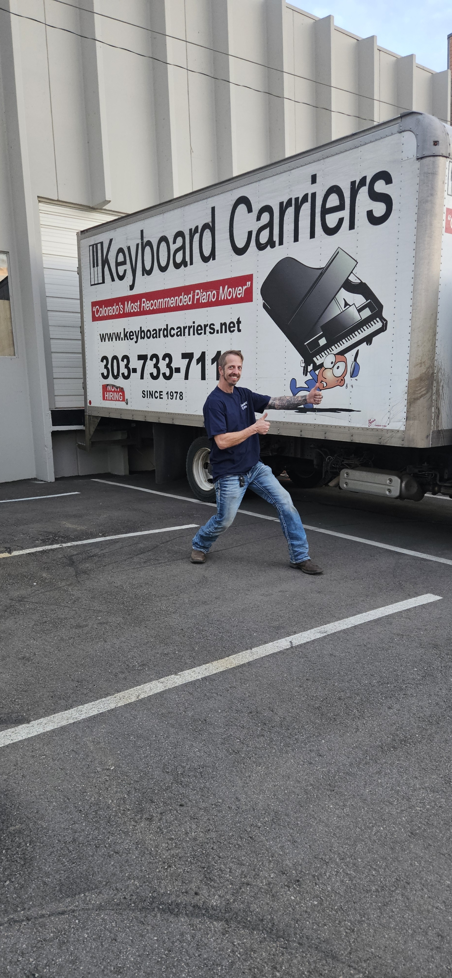 Man posing in front of moving truck.