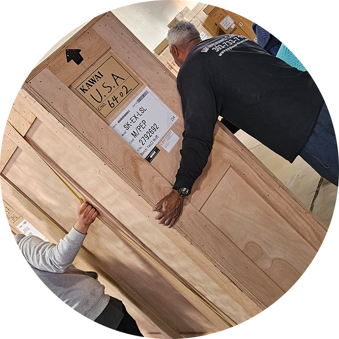 Two people handling a large wooden crate.