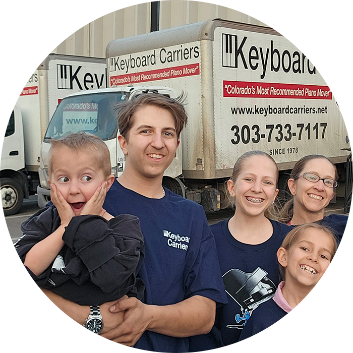 A happy family posing together with a keyboard camera backdrop.