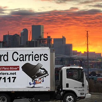 Delivery truck with a sunset cityscape backdrop.