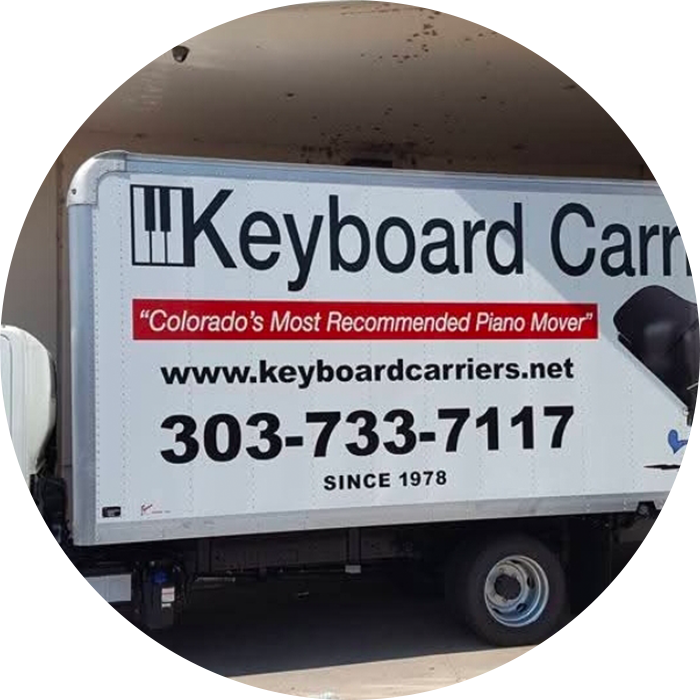Piano moving truck with business information displayed.
