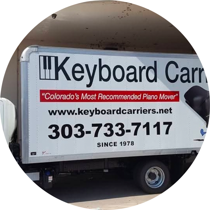 Piano moving truck with company details displayed.