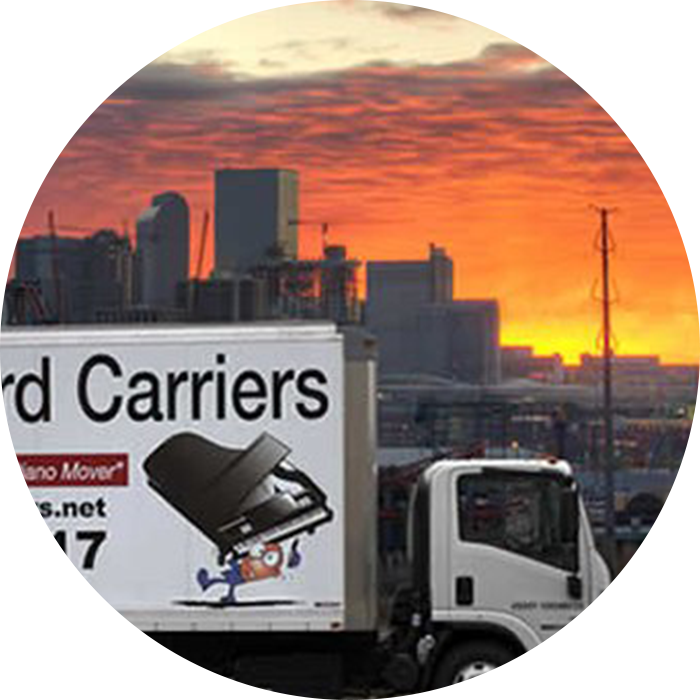 Truck at sunset with city skyline background.