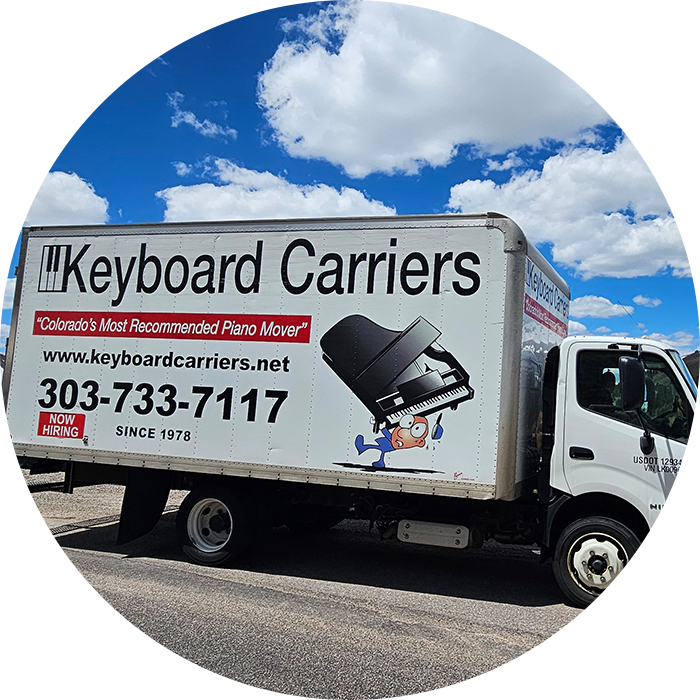 Moving truck with Keyboard Carriers advertisement and contact details.