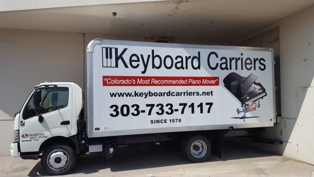Truck with Keyboard Carriers advertisement parked.